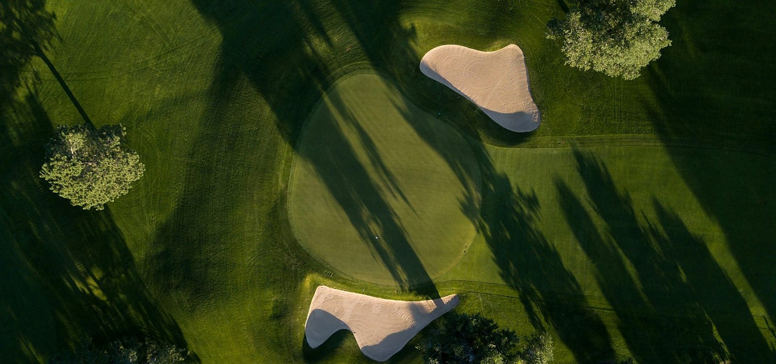 Aerial view of the Greenmere course green surrounded by bunkers and trees
