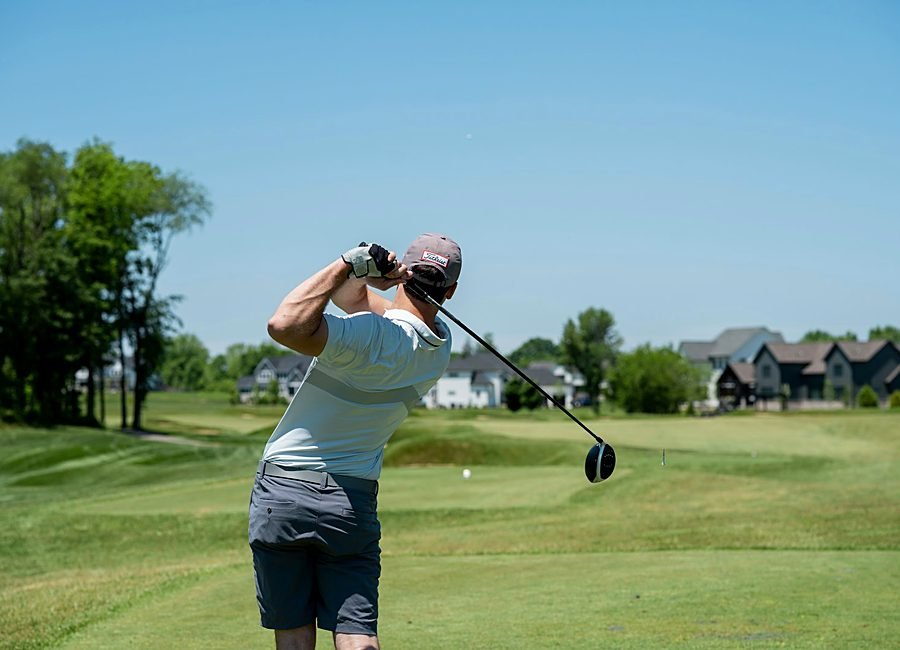 Golfer hitting practice balls in neat rows on the driving range