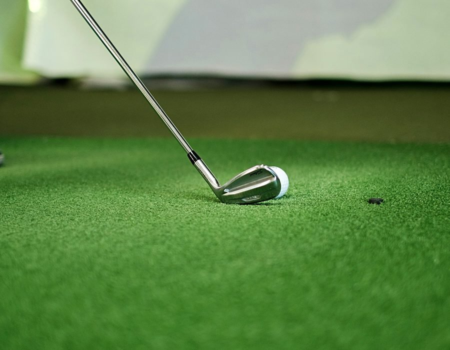 Close-up of a golf club striking a ball at the practice range