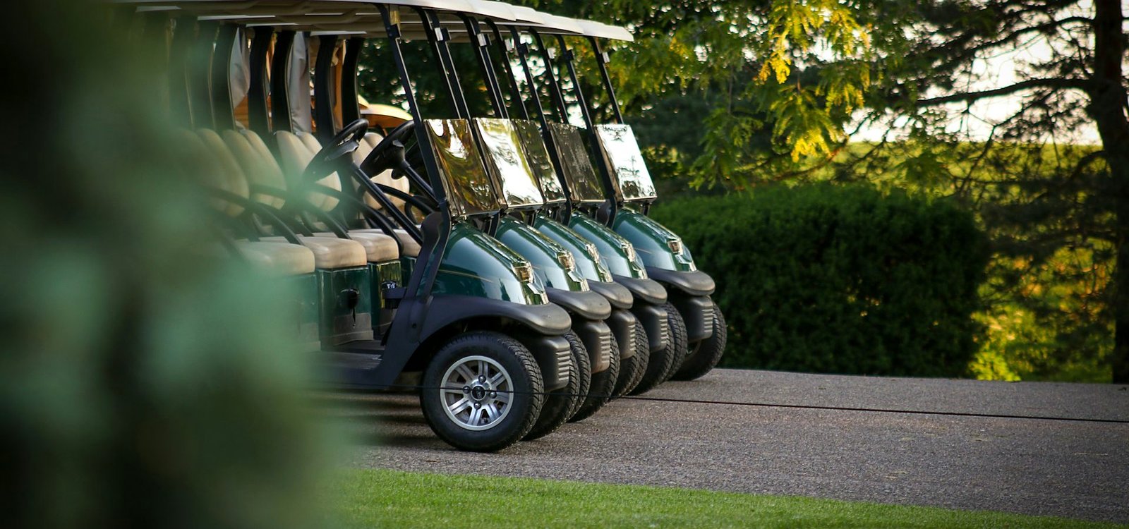 Golf cart parked on the cart path beside the fairway at Greenmere